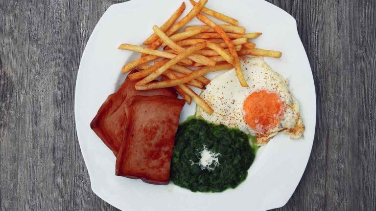 Plate of fries, eggs, spinach, and spam